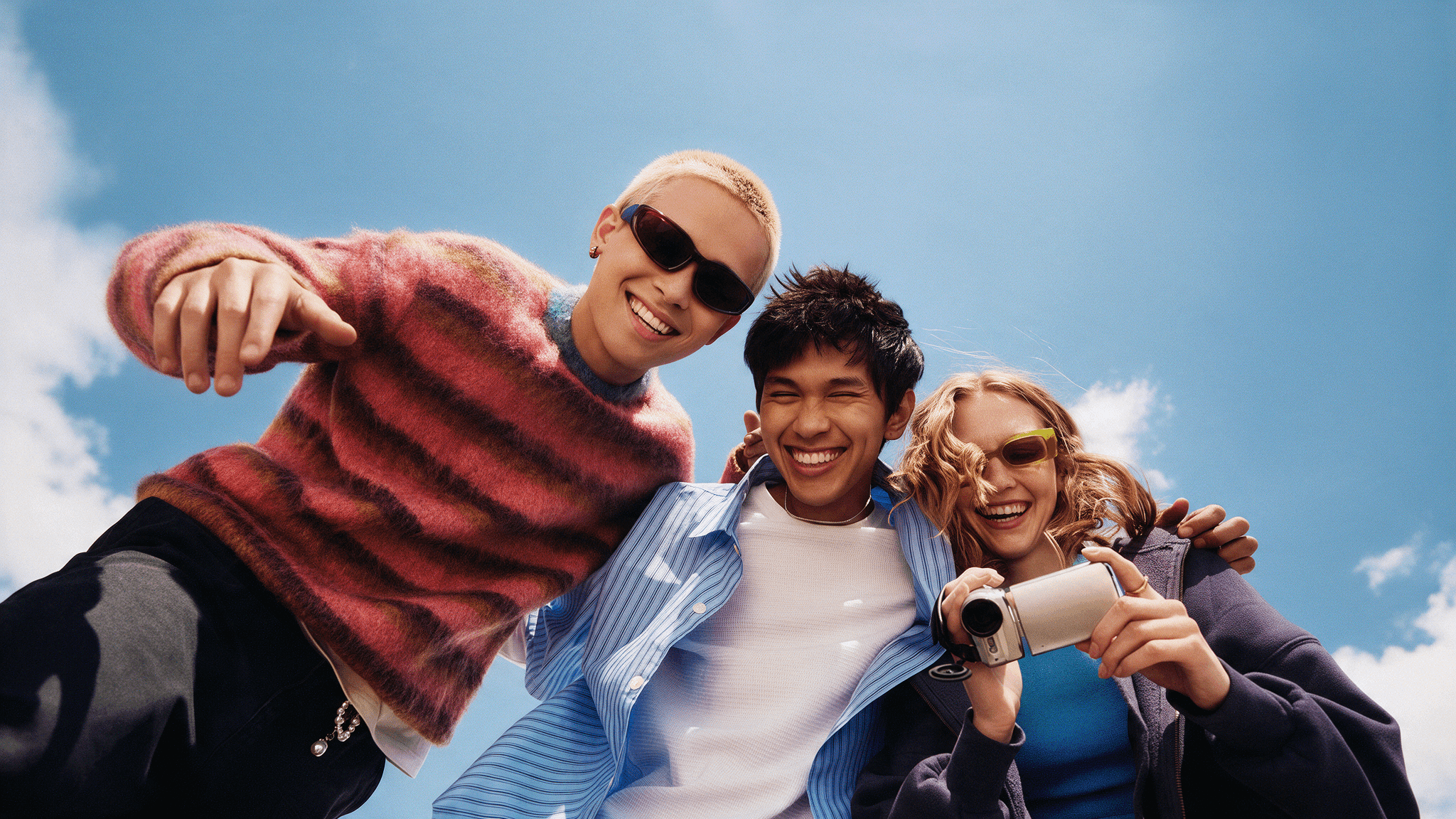 a group of young people smiling whole taping on camera